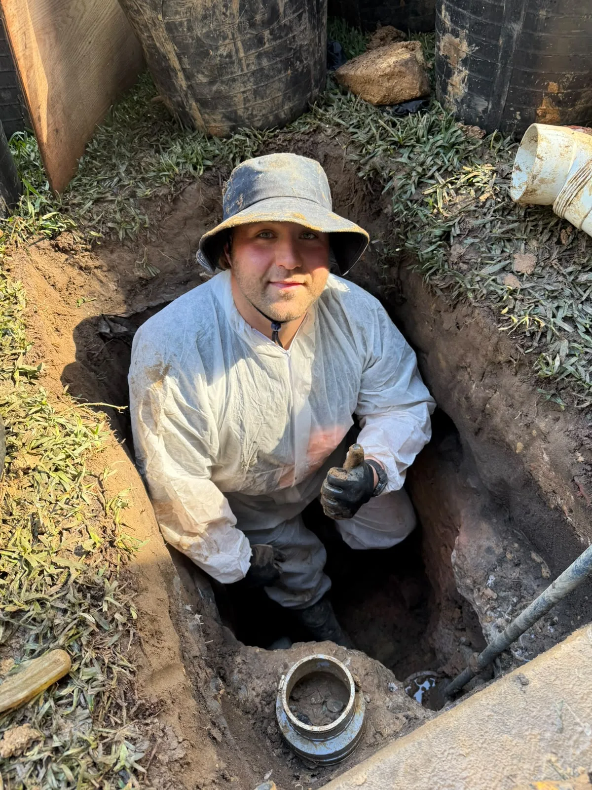A plumber excavating to reach a root-blocked sewer line