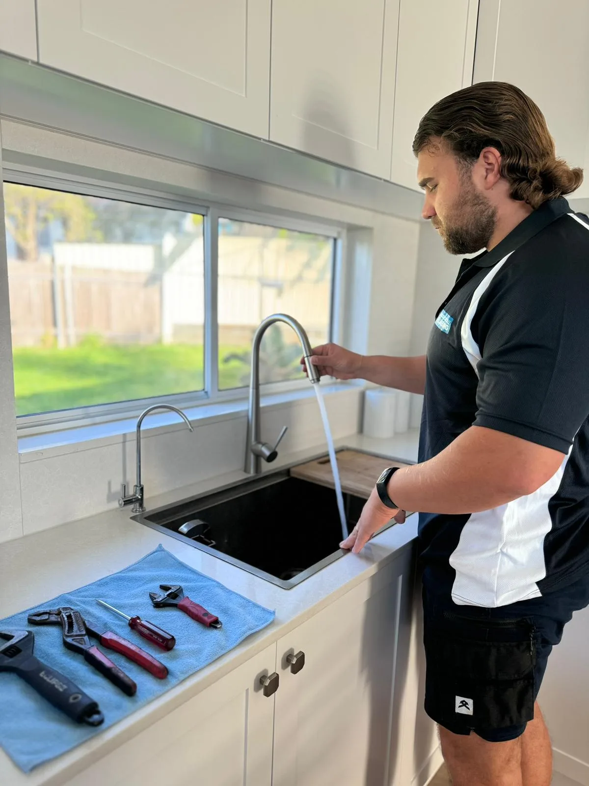 A plumber repairing a kitchen mixer tap